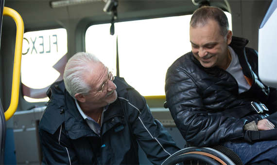 sénior et quarantenaire en fauteuil roulant discutant dans un transport Flexo